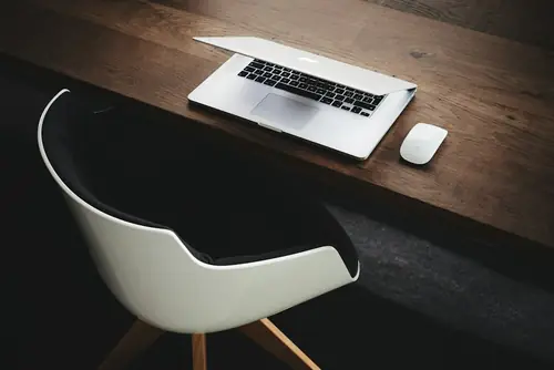 A laptop on a dark wood desk